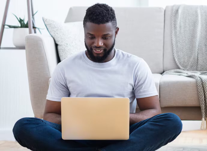 Sitzender Mann bei der Arbeit mit Notebook